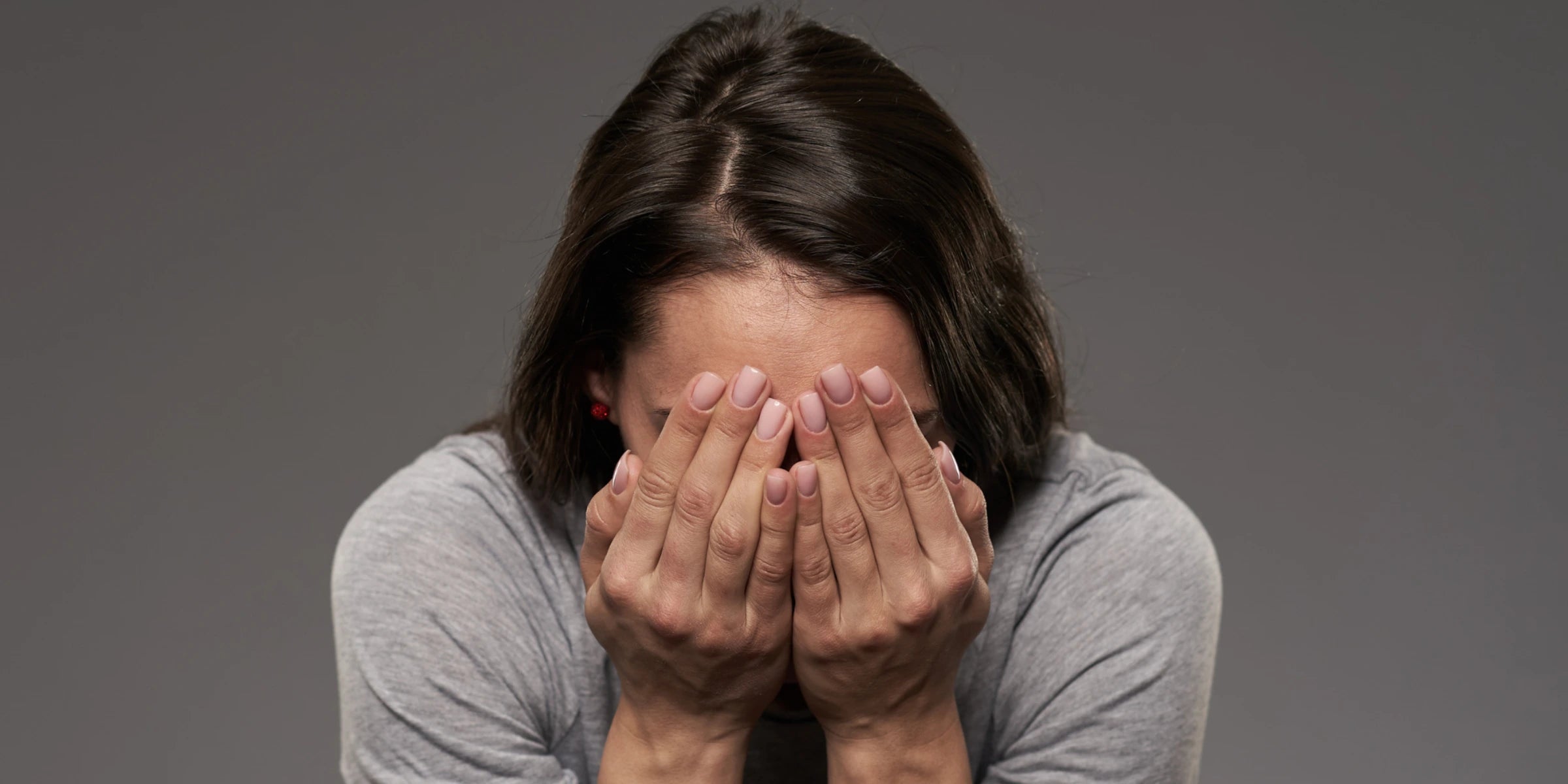 Frau hält vor Freude und Überraschung die Hände vor das Gesicht – emotionale Reaktion auf ein Geschenk, perfekte Darstellung für besondere Überraschungsmomente