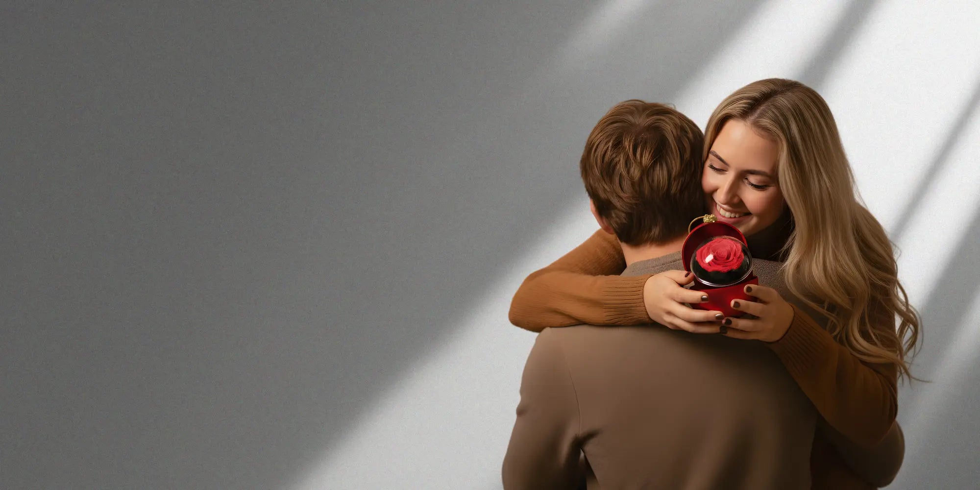 Glückliches Paar, Frau überrascht ihren Partner mit einer roten Amorlune Geschenkbox – perfekte Geschenkidee für besondere Anlässe, Liebe und romantische Momente