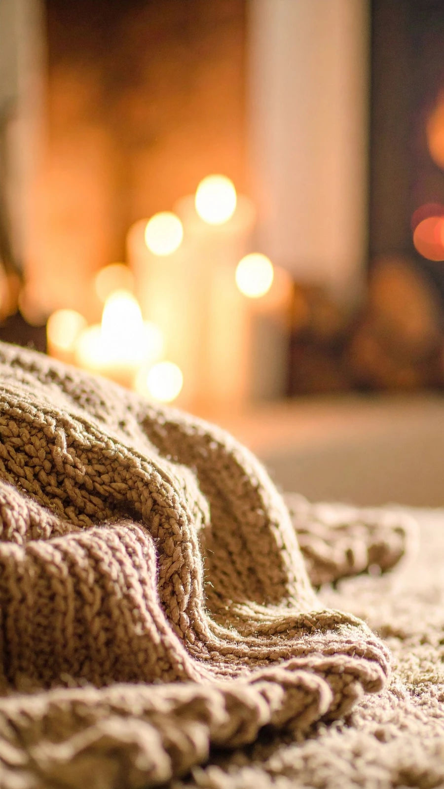 Weiche Amorlune Kuscheldecke auf Sofa vor Kaminfeuer – perfekte Geschenkidee für Gemütlichkeit, Wohlfühlmomente und entspannte Abende zuhause