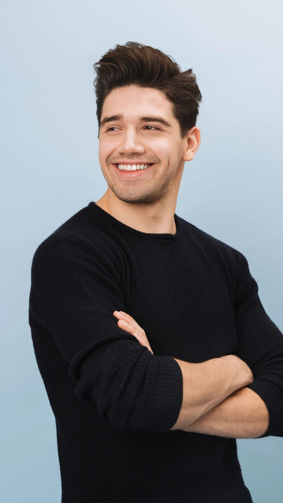 Junger Mann mit dunklem Pullover lächelt und blickt zur Seite – moderne Geschenkidee für Männer, Lebensfreude und Stil von Amorlune