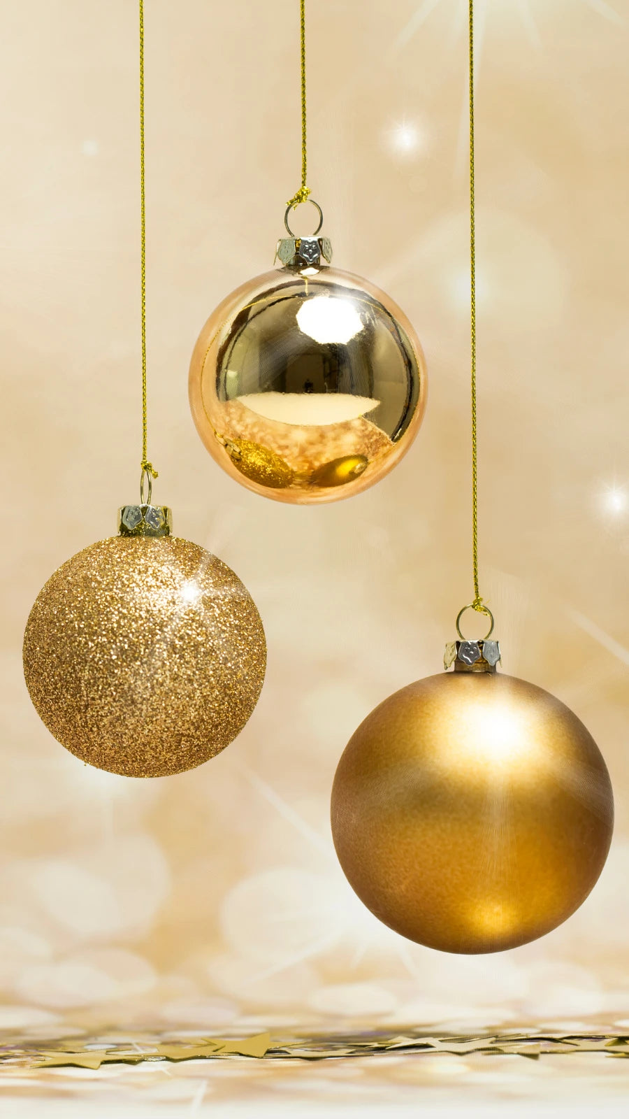 Drei goldene Weihnachtskugeln vor festlichem, goldenem Hintergrund – elegante Weihnachtsdekoration und stimmungsvolle Gestaltungsidee für die Feiertage